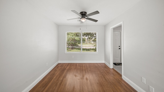 empty room featuring ceiling fan and dark hardwood / wood-style flooring