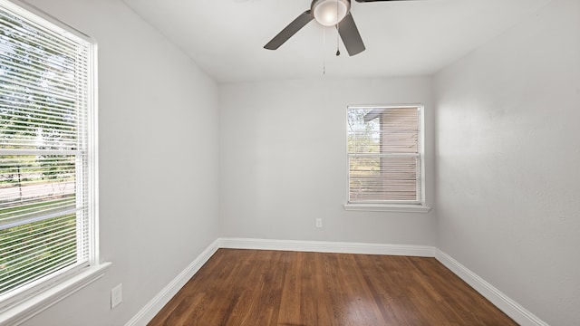 empty room featuring dark hardwood / wood-style flooring, a wealth of natural light, and ceiling fan