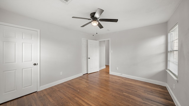 unfurnished bedroom featuring ceiling fan and dark hardwood / wood-style flooring