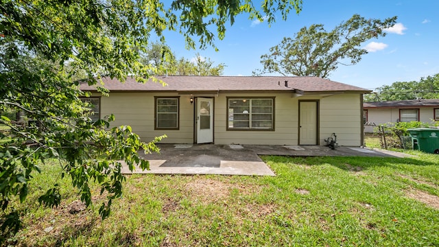 back of house featuring a lawn and a patio area