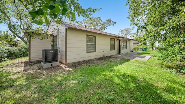 back of house with central AC, a patio, and a lawn