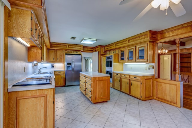 kitchen featuring light hardwood / wood-style flooring, a center island, ceiling fan with notable chandelier, appliances with stainless steel finishes, and sink