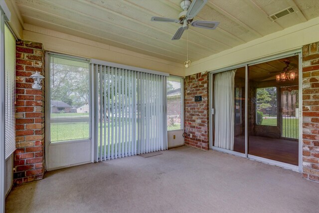 unfurnished sunroom featuring ceiling fan with notable chandelier