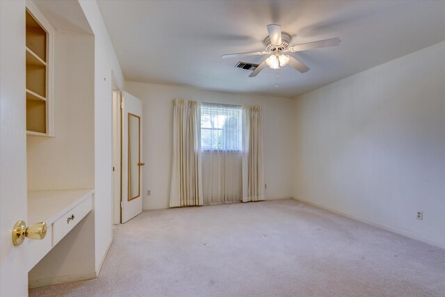 unfurnished room with light colored carpet and ceiling fan