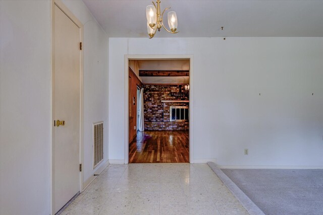 hallway with light hardwood / wood-style flooring and a chandelier