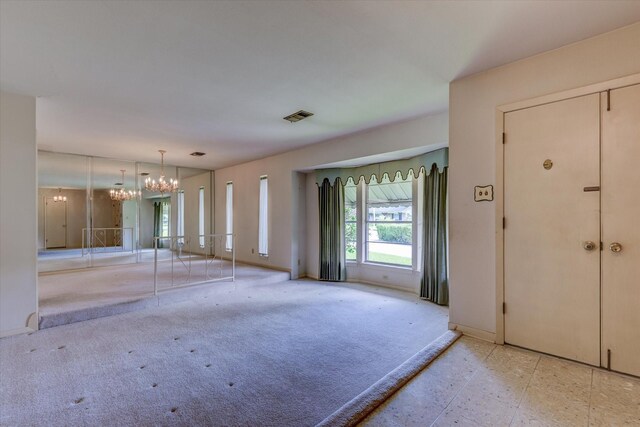 interior space with light carpet and a chandelier