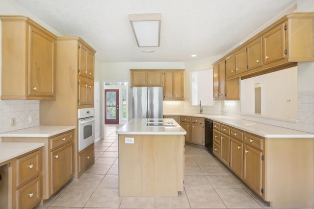 kitchen with a center island, light tile patterned floors, backsplash, and black appliances