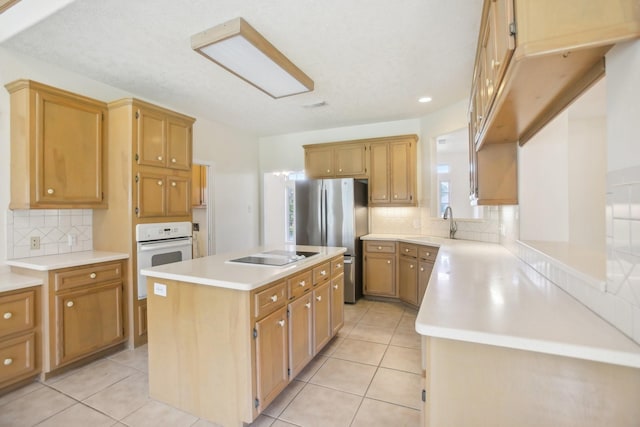 kitchen with a center island, white oven, stainless steel fridge, black electric stovetop, and decorative backsplash