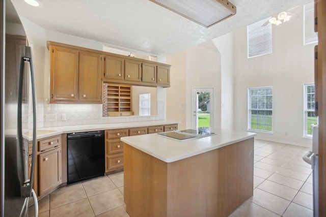 kitchen with decorative backsplash, light tile patterned floors, a kitchen island, and black appliances