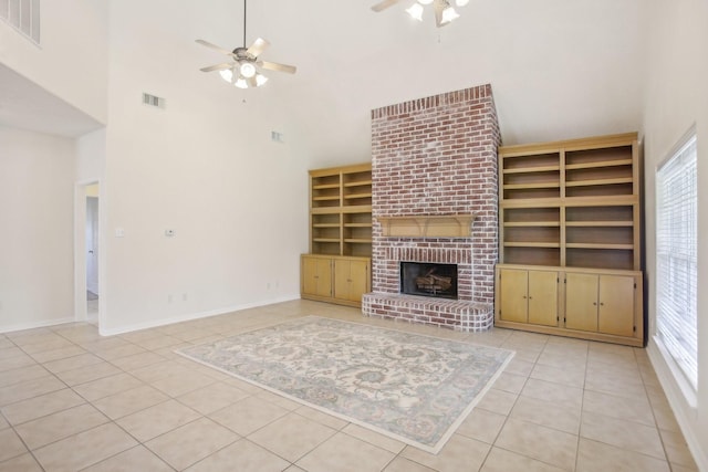 unfurnished living room featuring a wealth of natural light, built in features, ceiling fan, and light tile patterned flooring