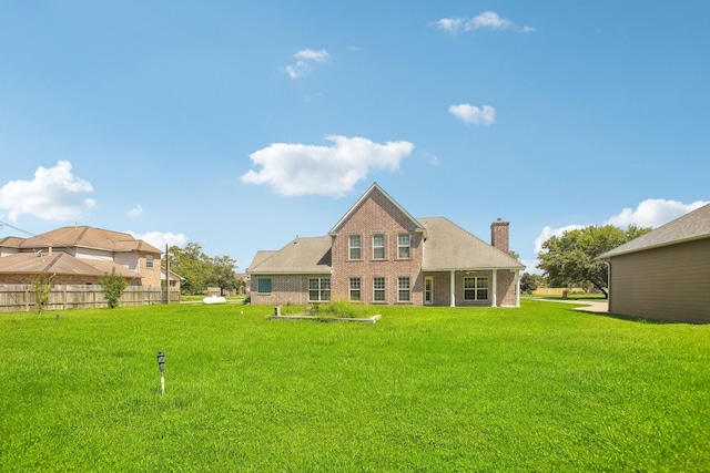 rear view of property with a lawn