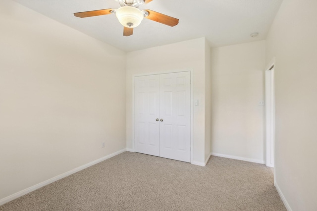 unfurnished bedroom featuring light colored carpet, a closet, and ceiling fan