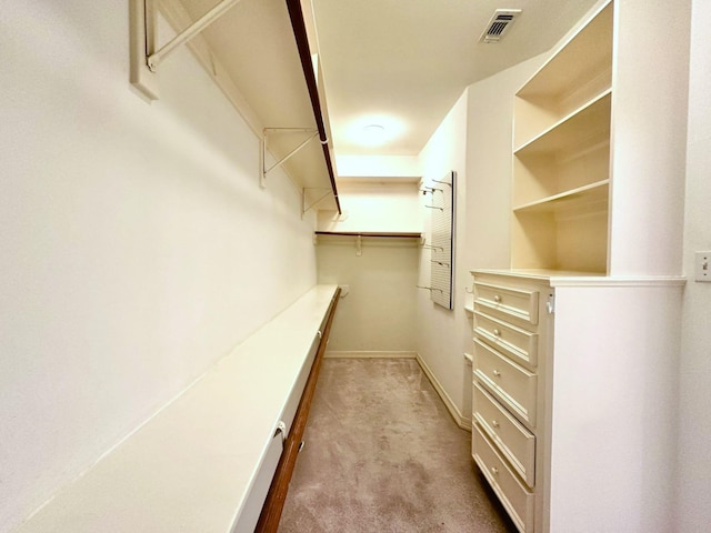 walk in closet featuring light carpet