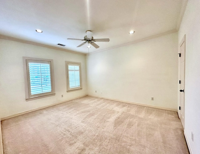 empty room with crown molding, light colored carpet, and ceiling fan