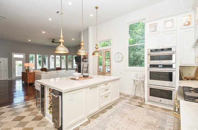 kitchen with light hardwood / wood-style floors, double oven, and white cabinetry