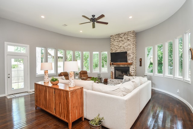 living room featuring plenty of natural light, a fireplace, and dark wood-type flooring