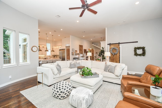 living room featuring hardwood / wood-style floors, sink, ceiling fan, and a barn door