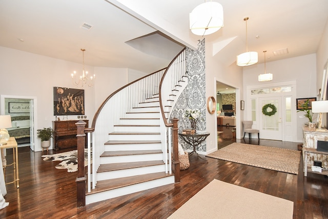 foyer entrance featuring a high ceiling, a chandelier, and dark hardwood / wood-style floors