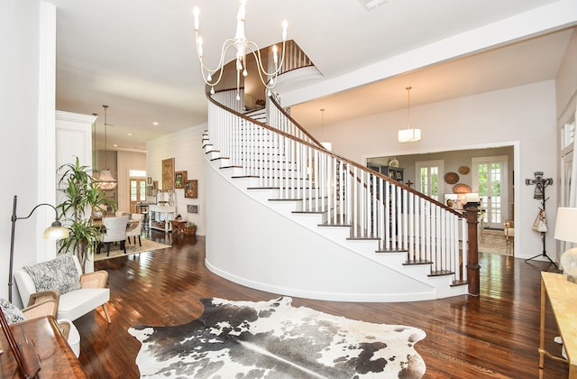 stairway featuring dark hardwood / wood-style flooring and an inviting chandelier