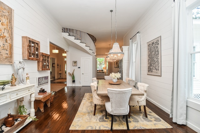 dining space with dark hardwood / wood-style floors and a notable chandelier