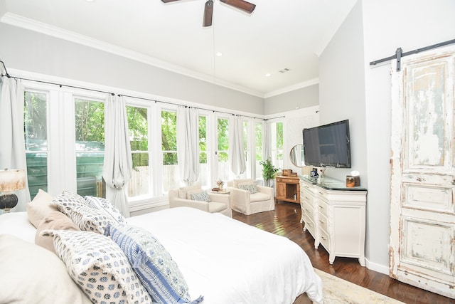 bedroom with multiple windows, a barn door, ceiling fan, and dark wood-type flooring