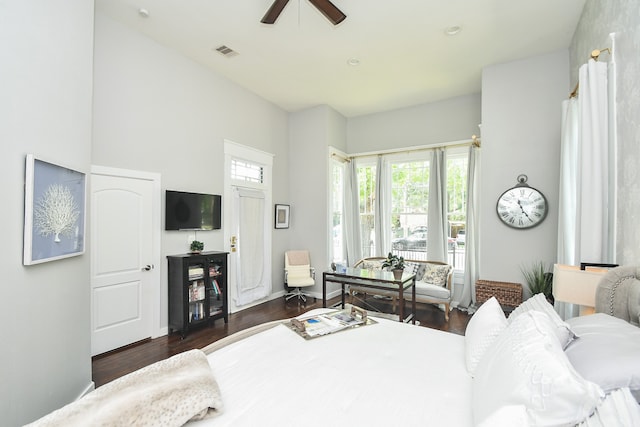 bedroom with ceiling fan, a towering ceiling, and dark wood-type flooring