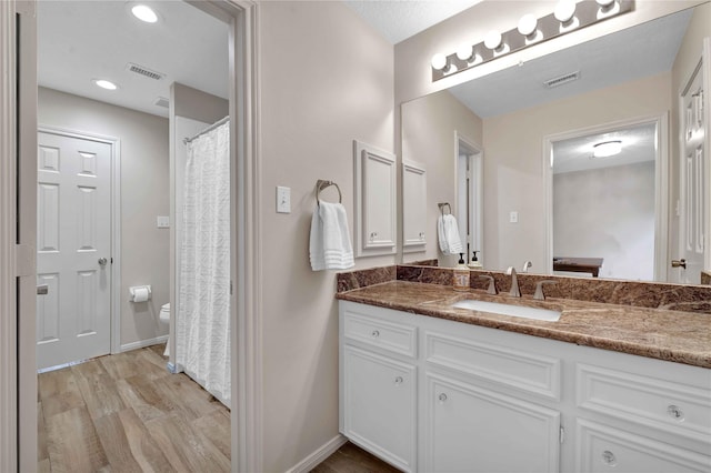 bathroom with vanity, hardwood / wood-style floors, and toilet