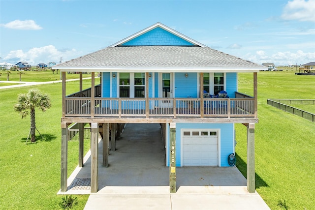 view of front of property with a garage, a front yard, a carport, and a porch