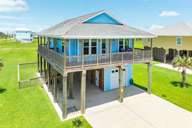 rear view of property featuring a garage, a carport, covered porch, and a lawn