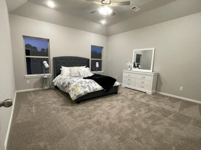 carpeted bedroom with ceiling fan, a raised ceiling, and vaulted ceiling