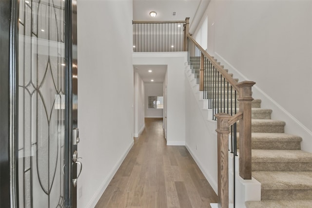 foyer featuring a towering ceiling and light hardwood / wood-style floors