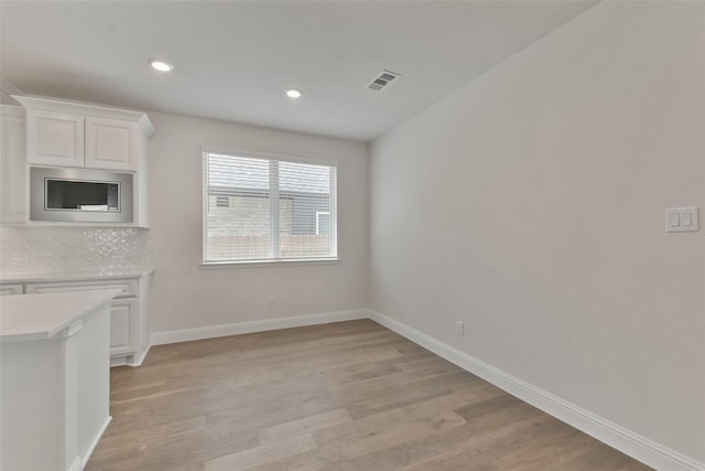 unfurnished dining area featuring light wood-type flooring