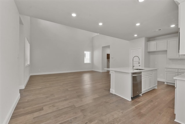 kitchen featuring dishwasher, sink, a center island with sink, and white cabinets