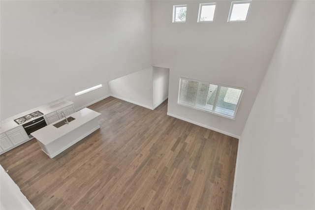 unfurnished living room with hardwood / wood-style flooring and sink