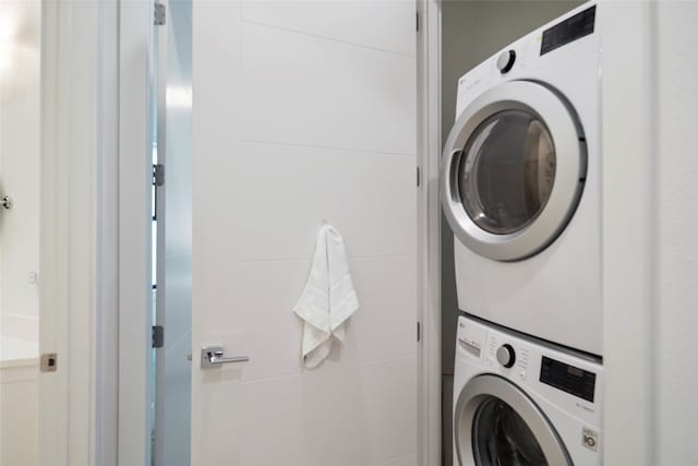 clothes washing area with stacked washer and clothes dryer