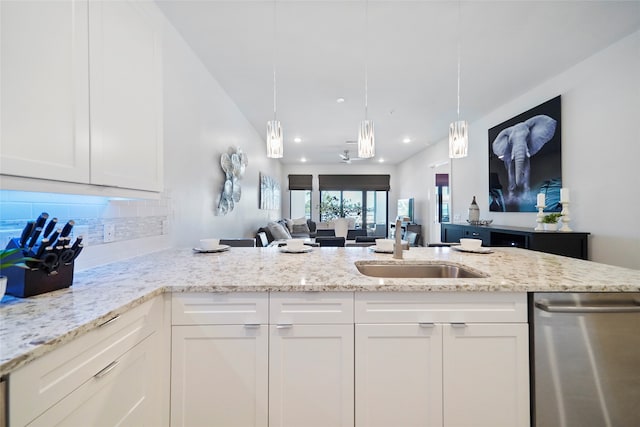 kitchen with white cabinets, sink, decorative backsplash, light stone countertops, and dishwasher