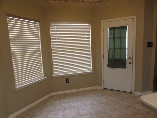 doorway to outside with a wealth of natural light and light tile patterned floors