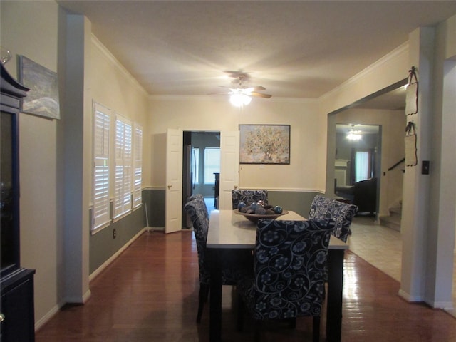 dining area with ornamental molding, ceiling fan, and dark wood-type flooring