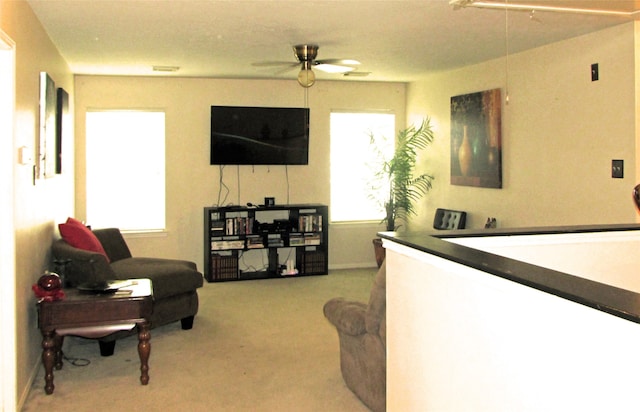 living room featuring light colored carpet, a wealth of natural light, and ceiling fan