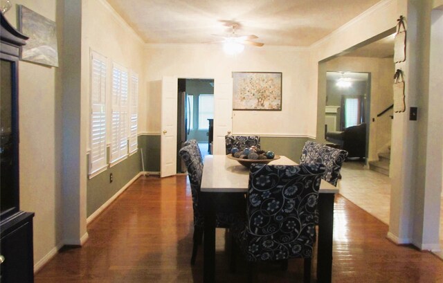 dining space featuring dark wood-type flooring, ornamental molding, and ceiling fan