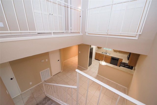 stairs featuring sink and tile patterned floors