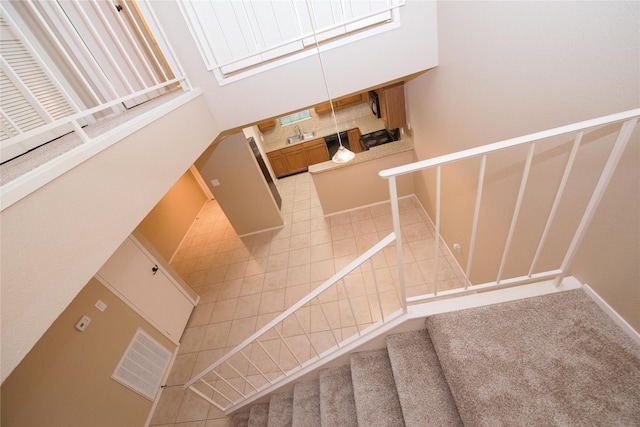 staircase featuring a towering ceiling and tile patterned floors