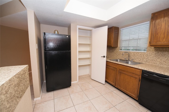 kitchen featuring backsplash, light tile patterned floors, sink, and black appliances