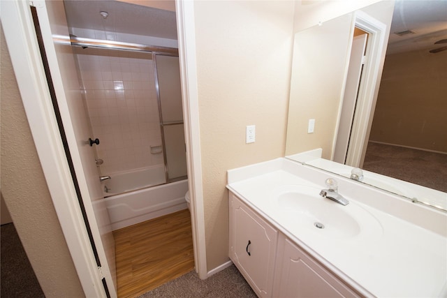 full bathroom with vanity, hardwood / wood-style floors, shower / bath combination with glass door, and toilet