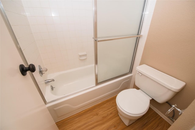 bathroom with bath / shower combo with glass door, wood-type flooring, and toilet