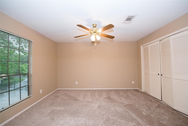 unfurnished bedroom featuring light colored carpet, ceiling fan, and a closet