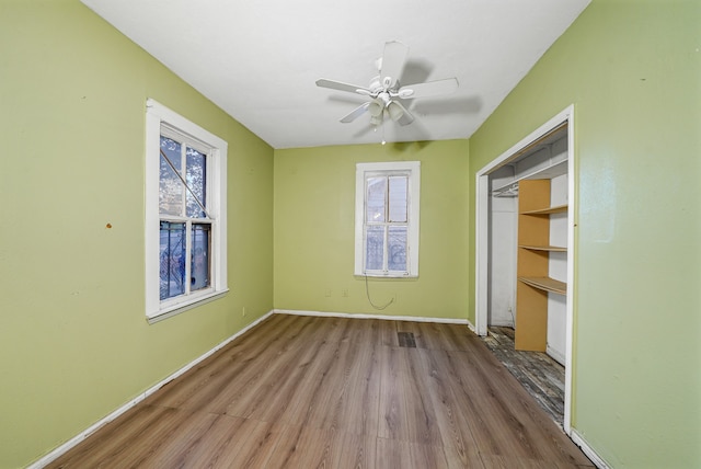 unfurnished bedroom featuring a closet, wood-type flooring, and ceiling fan