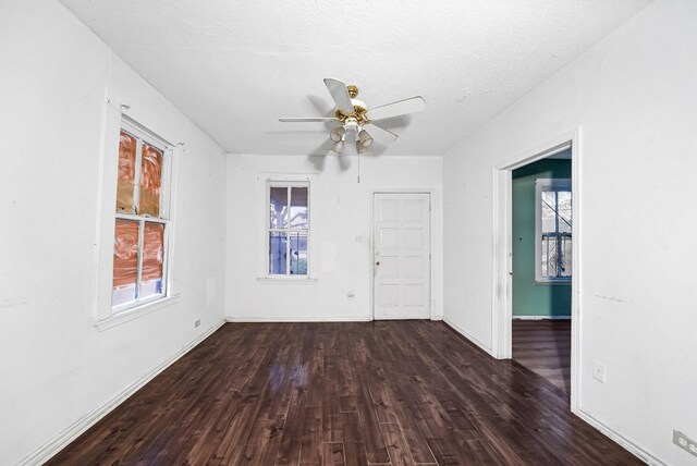 spare room featuring a textured ceiling, a healthy amount of sunlight, ceiling fan, and hardwood / wood-style floors