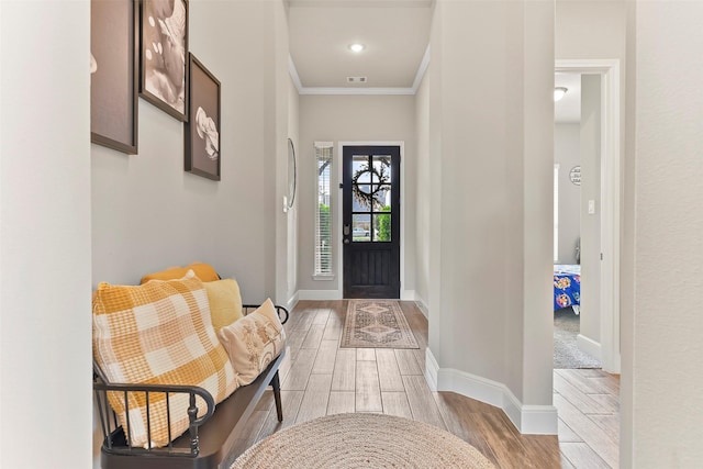 entrance foyer with light hardwood / wood-style flooring and ornamental molding