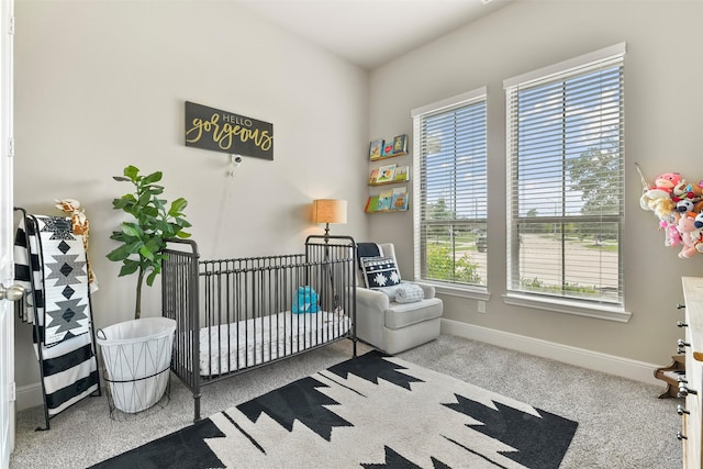 carpeted bedroom with a nursery area